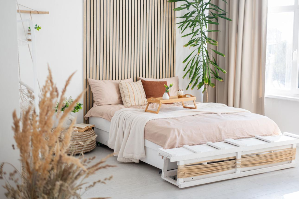 Cozy neutral bedroom with wooden headboard, soft bedding and natural light