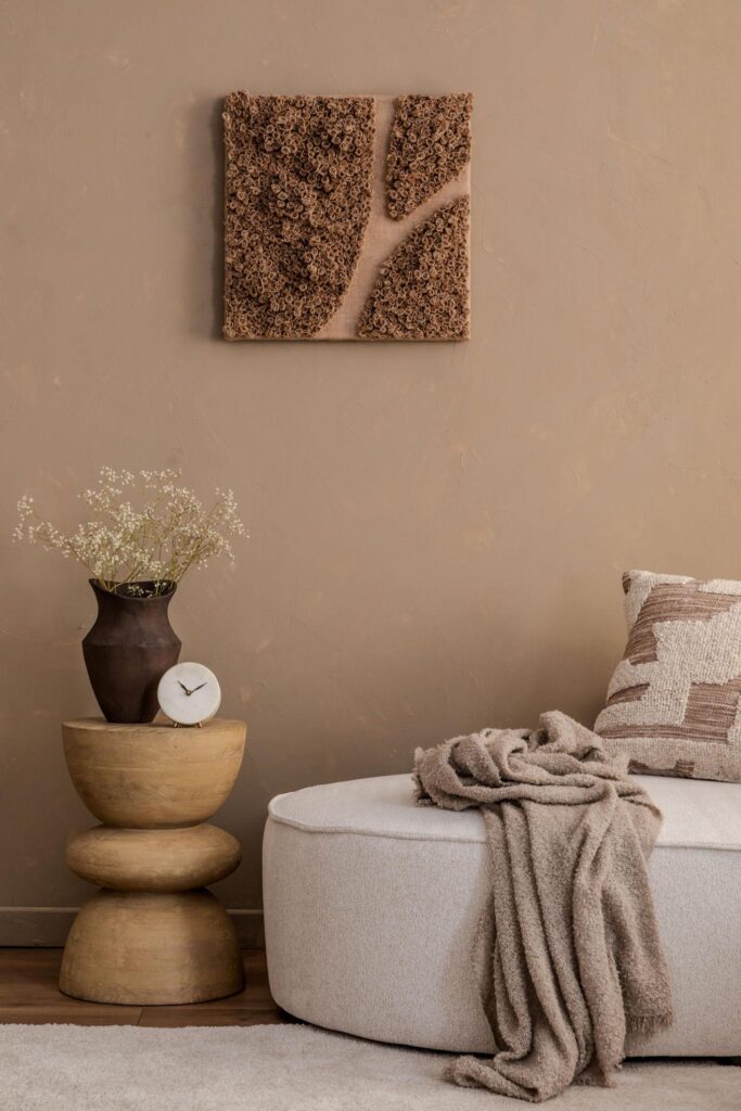 Neutral home decor with beige tones, textured wall art, vase and cozy seating